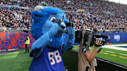 Buffalo Bills mascot Billy Buffalo interacts with WHAM TV camera person Jenna Cottrell during an NFL International Series game