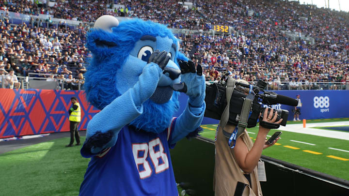 Buffalo Bills mascot Billy Buffalo interacts with WHAM TV camera person Jenna Cottrell during an NFL International Series game