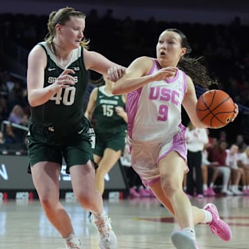 Feb 19, 2025; Los Angeles, California, USA; Southern California Trojans guard Kayleigh Heckel (9) dribbles the ball against Michigan State Spartans guard Julia Ayrault (40) in the first half at Galen Center. Mandatory Credit: Kirby Lee-Imagn Images