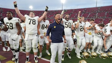 Nov 30, 2024; Los Angeles, California, USA; Notre Dame Fighting Irish head coach Marcus Freeman celebrates with players at the end of the game against the Southern California Trojans at United Airlines Field at Los Angeles Memorial Coliseum. Mandatory Credit: Kirby Lee-Imagn Images