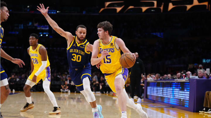 Apr 9, 2024; Los Angeles, California, USA;Los Angeles Lakers guard Austin Reaves (15) drives to the basket against Golden State Warriors guard Stephen Curry (30) in the first half at Crypto.com Arena. Mandatory Credit: Kirby Lee-USA TODAY Sports