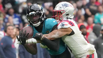 Oct 20, 2024; London, United Kingdom; Jacksonville Jaguars wide receiver Brian Thomas Jr. (7) catches a 58-yard pass against New England Patriots cornerback Christian Gonzalez (0) in the first half of an NFL International Series game at Wembley Stadium. Mandatory Credit: Kirby Lee-Imagn Images