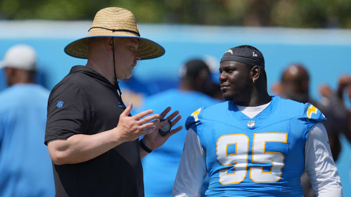 Jun 13, 2024; Costa Mesa, CA, USA; Los Angeles Chargers executive director of player performance Ben Herbert (left) talks with defensive tackle Poona Ford (95)s during minicamp at the Hoag Performance Center. Mandatory Credit: Kirby Lee-Imagn Images