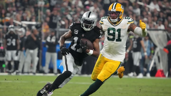 Oct 9, 2023; Paradise, Nevada, USA; Las Vegas Raiders wide receiver Davante Adams (17) is pursued by Green Bay Packers linebacker Preston Smith (91) in the second half at Allegiant Stadium. Mandatory Credit: Kirby Lee-USA TODAY Sports