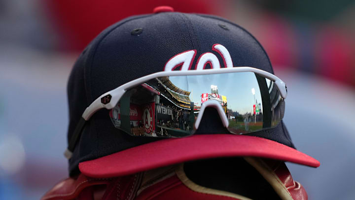 May 7, 2022; Anaheim, California, USA; A detailed view of a Washington Nationals cap and glove with sunglasses in the dugout before a game against the Los Angeles Angels at Angel Stadium.