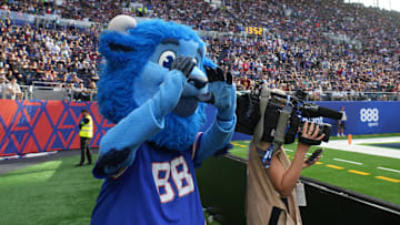 Buffalo Bills mascot Billy Buffalo interacts with WHAM TV camera person Jenna Cottrell during an NFL International Series game at Tottenham Hotspur Stadium. 