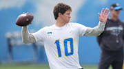 Los Angeles Chargers quarterback Justin Herbert throws the ball as coach Jim Harbaugh watches during offseason workouts at The Bolt. 