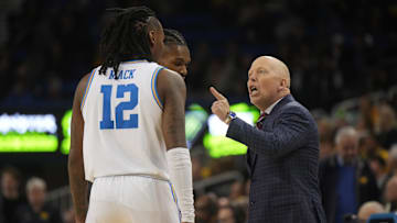 Jan 7, 2025; Los Angeles, California, USA; UCLA Bruins head coach Mick Cronin talks with guard Sebastian Mack (12) in the first half against the Michigan Wolverines at Pauley Pavilion presented by Wescom. Mandatory Credit: Kirby Lee-Imagn Images