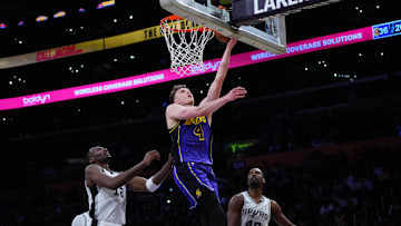 Mar 17, 2025; Los Angeles, California, USA; Los Angeles Lakers guard Dalton Knecht (4) shoots the ball against San Antonio Spurs center Bismack Biyombo (18) and forward Harrison Barnes (40) in the first half at Crypto.com Arena. Mandatory Credit: Kirby Lee-Imagn Images