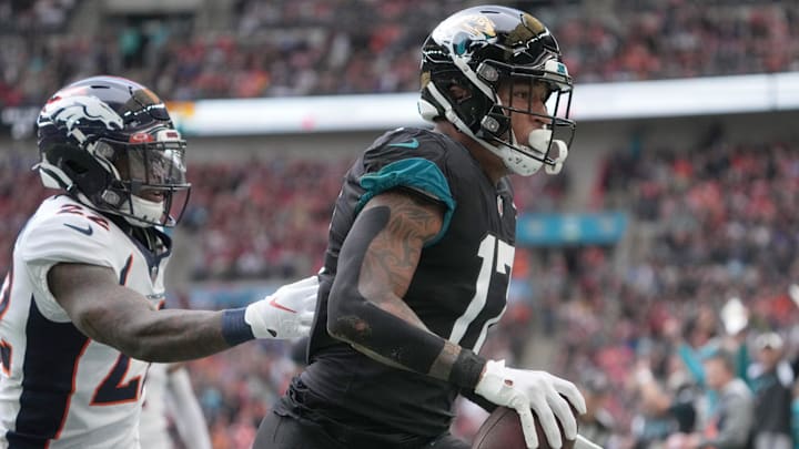 Oct 30, 2022; London, United Kingdom; Jacksonville Jaguars tight end Evan Engram (17) catches a touchdown pass as Denver Broncos safety Kareem Jackson (22) defends in the first quarter during an NFL International Series game at Wembley Stadium. Mandatory Credit: Kirby Lee-Imagn Images