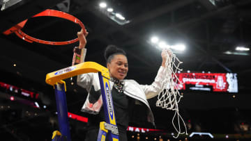 South Carolina basketball coach Dawn Staley cutting down the nets after her third national championship