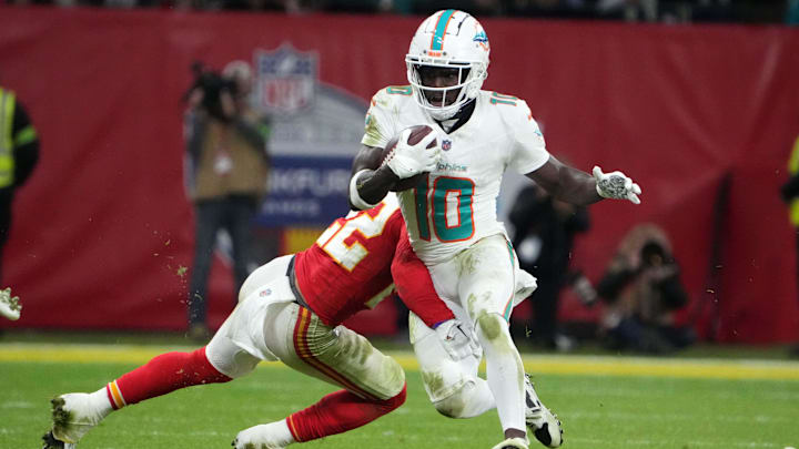Nov 5, 2023; Frankfurt, Germany; Miami Dolphins wide receiver Tyreek Hill (10) carries the ball against Kansas City Chiefs linebacker Nick Bolton (32) in the second half during an NFL International Series game at Deutsche Bank Park. Mandatory Credit: Kirby Lee-Imagn Images