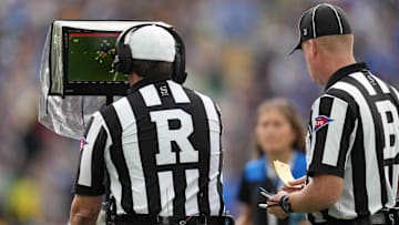 Oct 23, 2021; Pasadena, California, USA; NCAA referee Mark Duddy (R) and  back judge David Ross (B) video review a play in the second half of the game between the UCLA Bruins and the Oregon Ducks  at Rose Bowl. Oregon defeated UCLA 34-31.  Mandatory Credit: Kirby Lee-Imagn Images