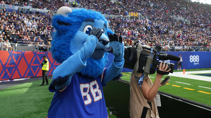 Buffalo Bills mascot Billy Buffalo interacts with WHAM TV camera person Jenna Cottrell during an NFL International Series game at Tottenham Hotspur Stadium.