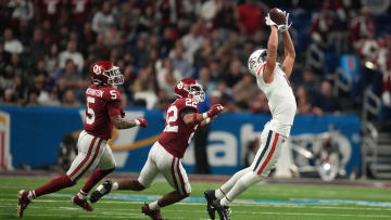 Dec 28, 2023; San Antonio, TX, USA; Arizona Wildcats wide receiver Tetairoa McMillan (4) catches the ball against Oklahoma Sooners defensive back Woodi Washington (5) and defensive back Peyton Bowen (22) in the fist half of the Alamo Bowl at Alamodome. 