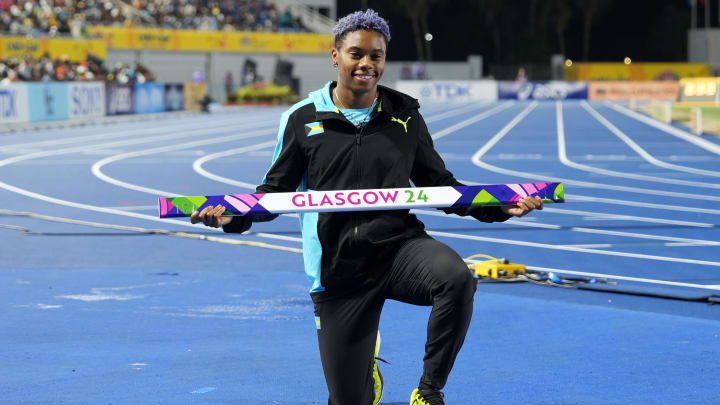 Devynne Charlton (BAH) poses with hurdle board from the 2024 Glasgow World Indoor Championships 