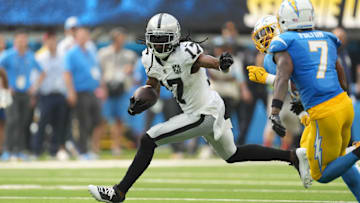 Sep 8, 2024; Inglewood, California, USA; Las Vegas Raiders wide receiver Davante Adams (17) carries the ball against Los Angeles Chargers cornerback Kristian Fulton (7) and linebacker Daiyan Henley (0) in the second half at SoFi Stadium. 