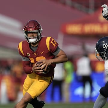 Sep 3, 2022; Los Angeles, California, USA; Southern California Trojans quarterback Caleb Williams (13) is pursued by Rice Owls defensive end Ikenna Enechukwu (91) in the third quarter at United Airlines Field at Los Angeles Memorial Coliseum. Mandatory Credit: Kirby Lee-Imagn Images