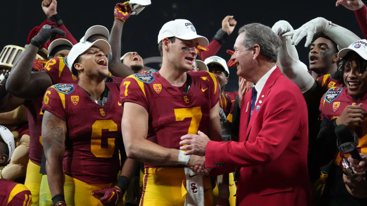 Dec 27, 2023; San Diego, CA, USA; Southern California Trojans quarterback Miller Moss (7) shakes hands with DirecTV Holiday Bowl president Dennis Dubard after victory over the Louisville Cardinals at Petco Park. Mandatory Credit: Kirby Lee-USA TODAY Sports