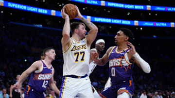 Mar 16, 2025; Los Angeles, California, USA; Los Angeles Lakers guard Luka Doncic (77) is defended by Phoenix Suns forward Ryan Dunn (0) in the second half at Crypto.com Arena. Mandatory Credit: Kirby Lee-Imagn Images