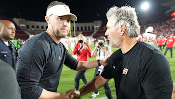 Oct 21, 2023; Los Angeles, California, USA; Utah Utes head coach Kyle Whittingham shakes hands with Southern California Trojans head coach Lincoln Riley after the game at United Airlines Field at Los Angeles Memorial Coliseum. Mandatory Credit: Kirby Lee-Imagn Images