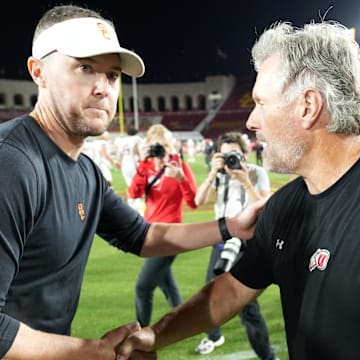 Oct 21, 2023; Los Angeles, California, USA; Utah Utes head coach Kyle Whittingham shakes hands with Southern California Trojans head coach Lincoln Riley after the game at United Airlines Field at Los Angeles Memorial Coliseum. Mandatory Credit: Kirby Lee-Imagn Images