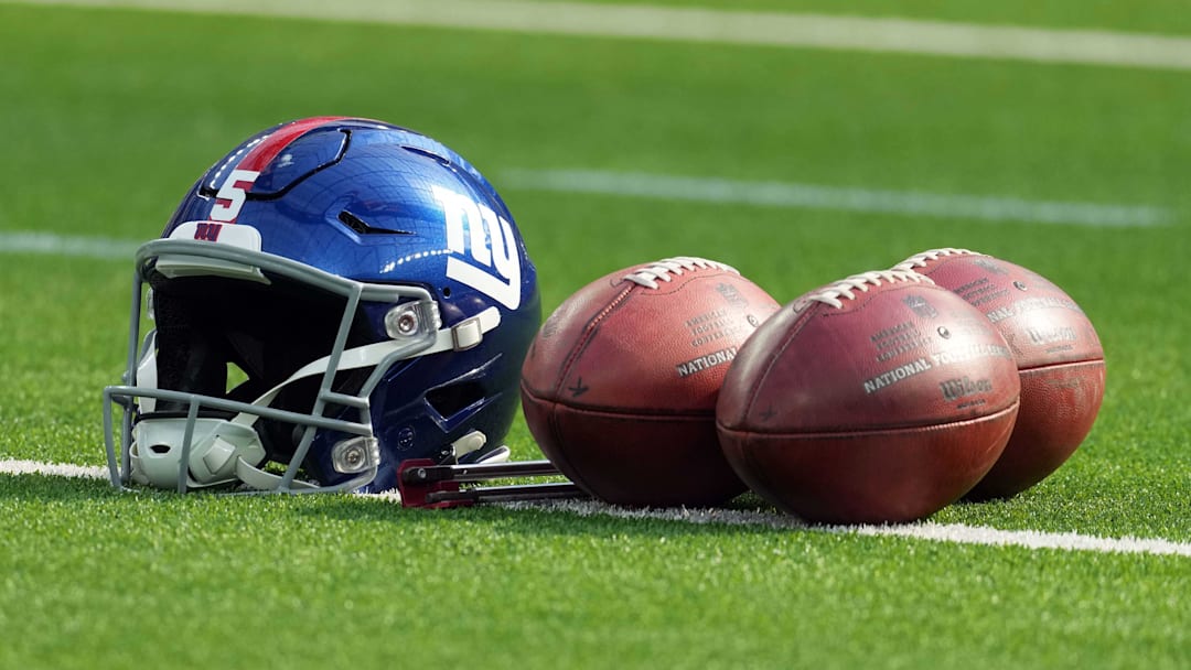 A detailed view of a New York Giants helmet and Wilson official NFL footballs.