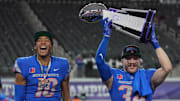 Boise State's Taylen Green (10) and Alexander Teubner pose with the Mountain West trophy. 