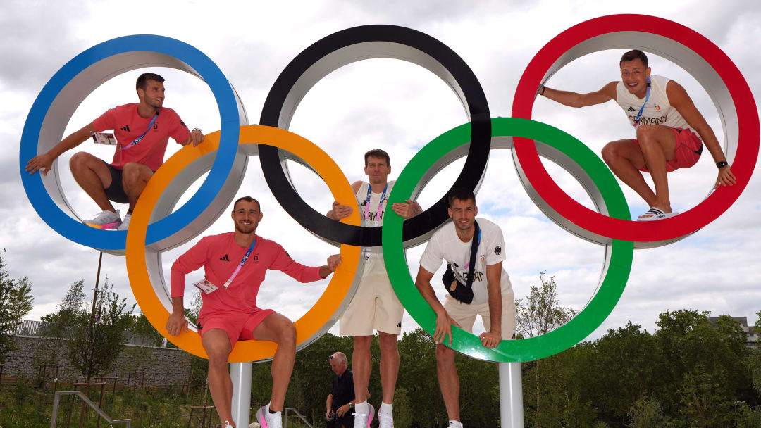 Members of the German volleyball team pose with the Olympic rings at the 2024 Paris Olympics athlete village