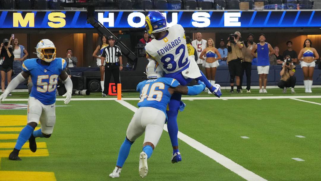 Aug 16, 2025; Inglewood, California, USA; Los Angeles Rams wide receiver Tru Edwards (82) catches an 8-yard touchdown pass against Los Angeles Chargers cornerback Nikko Reed (46) and linebacker Bud Dupree (48) in the fourth quarter at SoFi Stadium. Mandatory Credit: Kirby Lee-Imagn Images