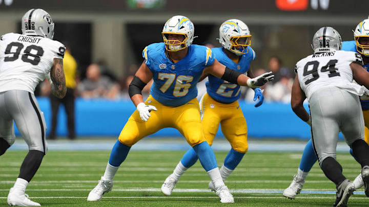 Sep 8, 2024; Inglewood, California, USA; Los Angeles Chargers offensive tackle Joe Alt (76) defends against Las Vegas Raiders defensive end Maxx Crosby (98) and  defensive tackle Christian Wilkins (94) in the first half at SoFi Stadium. Mandatory Credit: Kirby Lee-Imagn Images