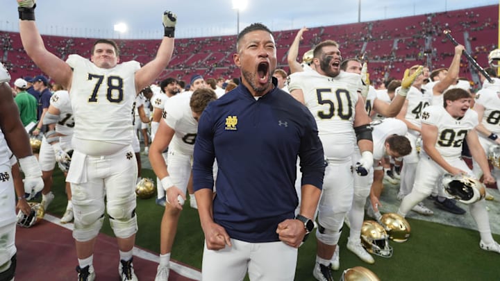 Notre Dame Fighting Irish head coach Freeman celebrates with players at the end of the game against USC. Notre Dame Fighting Irish head coach Freeman celebrates with players at the end of the game against USC.