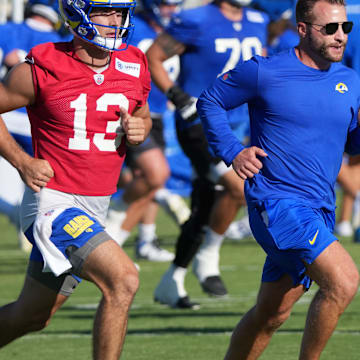 Los Angeles Rams coach Sean McVay runs with quarterback Stetson Bennett (13) during the team's training camp at Loyola Marymount University.