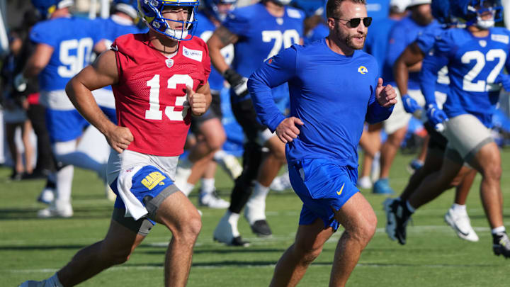 Los Angeles Rams coach Sean McVay runs with quarterback Stetson Bennett (13) during the team's training camp at Loyola Marymount University.