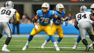 Sep 8, 2024; Inglewood, California, USA; Los Angeles Chargers offensive tackle Joe Alt (76) defends against Las Vegas Raiders defensive end Maxx Crosby (98) and  defensive tackle Christian Wilkins (94) in the first half at SoFi Stadium. Mandatory Credit: Kirby Lee-Imagn Images