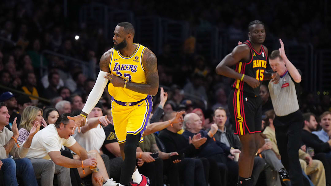 Mar 18, 2024; Los Angeles, California, USA; Los Angeles Lakers forward LeBron James (23) gestures after a three point basket against Atlanta Hawks center Clint Capela (15) in the first half at Crypto.com Arena. Mandatory Credit: Kirby Lee-Imagn Images