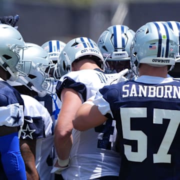 Dallas Cowboys players huddle at training camp at the River Ridge Fields.