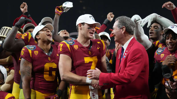 USC quarterback Miller Moss shakes hands with DirecTV Holiday Bowl president Dennis Dubard after a victory over Louisville.