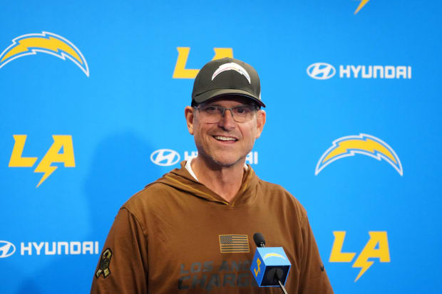 Head coach smiles during press conference.