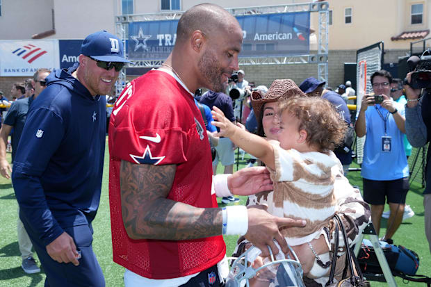 Dallas Cowboys quarterback Dak Prescott talks with fiancée Sarah Jane Ramos and daughter Aurora as QB coach Steve Shimko watc