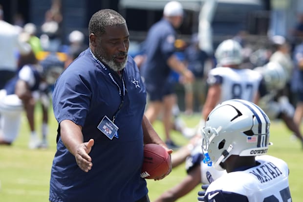 Dallas Cowboys defensive passing game coordinator Andre Curtis shakes hands with running back Phil Mafah at training camp 