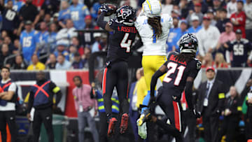 Jan 11, 2025; Houston, Texas, USA; Houston Texans corner back Kamari Lassiter (4) intercepts a pass for Los Angeles Chargers wide receiver Quentin Johnston (1) during the second quarter in an AFC wild card game at NRG Stadium. Mandatory Credit: Troy Taormina-Imagn Images