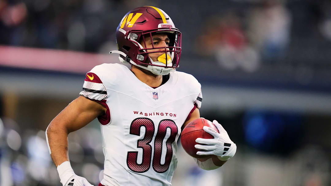 Austin Ekeler of the Washington Commanders returns a kickoff against the Dallas Cowboys