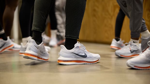 Runners wear white Nike shoes.