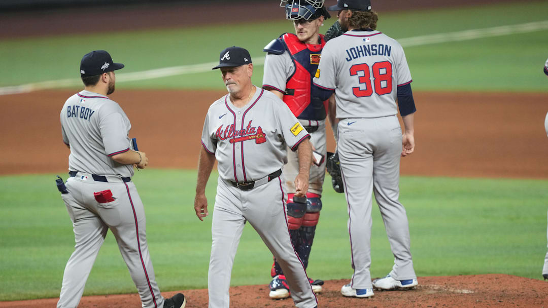 Jun 20, 2025; Miami, Florida, USA;  Atlanta Braves manager Brian Snitker, second from left, puts in pitcher Pierce Johnson (38) in the seventh inning against the Miami Marlins at loanDepot Park. Mandatory Credit: Jim Rassol-Imagn Images