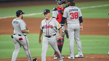 Jun 20, 2025; Miami, Florida, USA;  Atlanta Braves manager Brian Snitker, second from left, puts in pitcher Pierce Johnson (38) in the seventh inning against the Miami Marlins at loanDepot Park. Mandatory Credit: Jim Rassol-Imagn Images