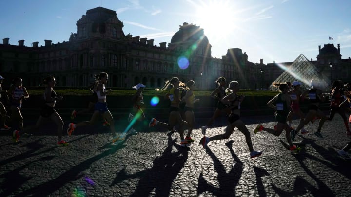 Runners make their way past the Louvre Museum in the women's marathon during the Paris 2024 Olympic Summer Games. 