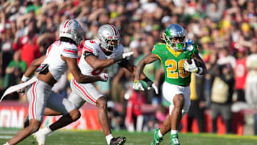 Jan 1, 2025; Pasadena, California, USA; Oregon Ducks running back Jordan James (20) carries the ball against Ohio State Buckeyes safety Sonny Styles (6) and cornerback Davison Igbinosun (1) during a CFP quarterfinal at Rose Bowl Stadium. Mandatory Credit: Kirby Lee-Imagn Images