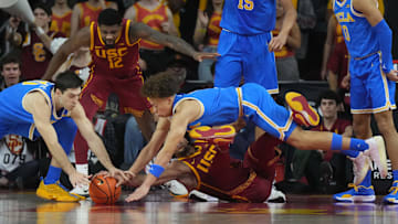 UCLA Bruins guard Trent Perry (1) and guard Lazar Stefanovic (10) battle for the ball with Southern California Trojans guard Desmond Claude (1) in the first half at Galen Center.