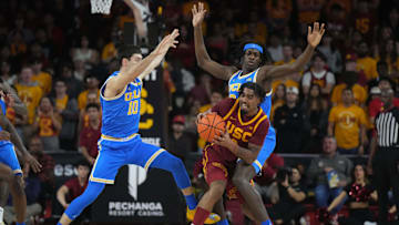 Southern California Trojans forward Saint Thomas is defended by UCLA Bruins guard Lazar Stefanovic and forward William Kyle III.